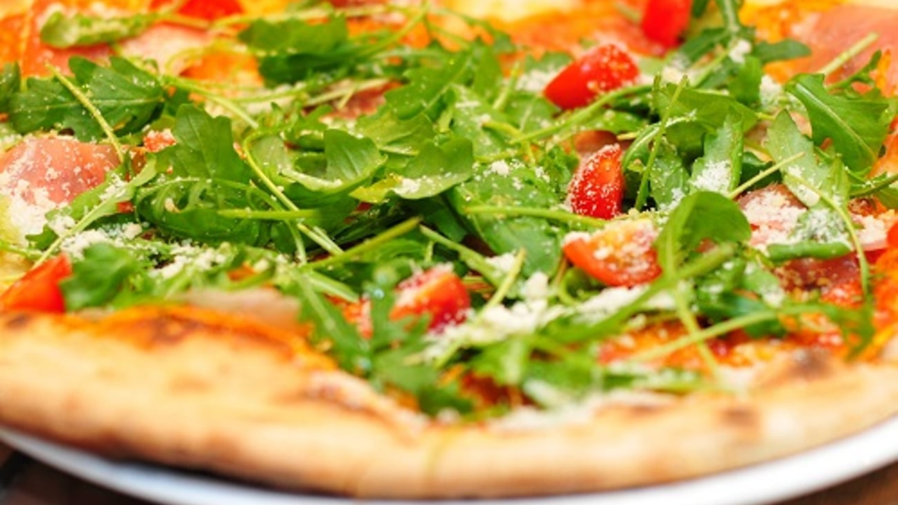 a pizza sitting on top of a wooden table