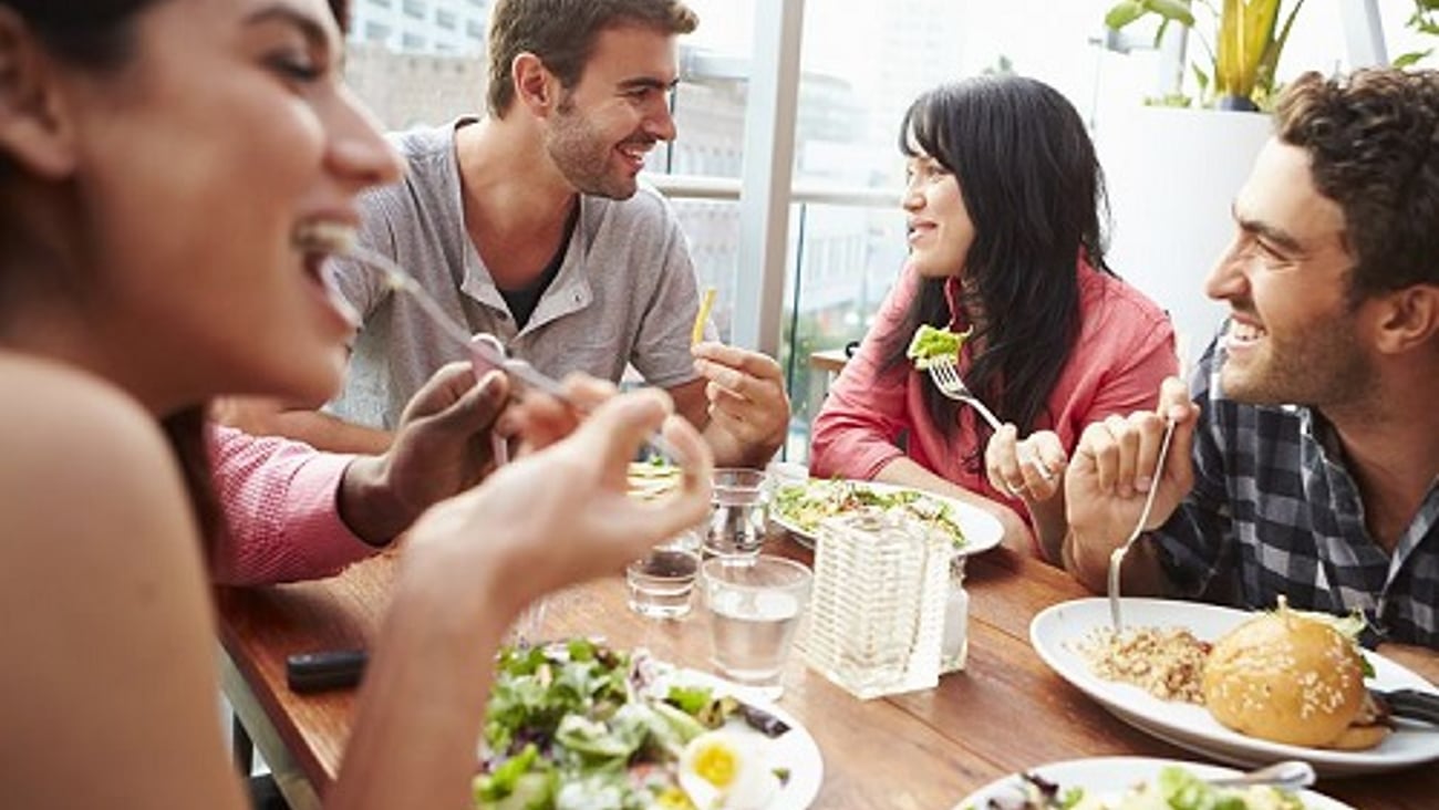 a group of people sitting at a table eating food