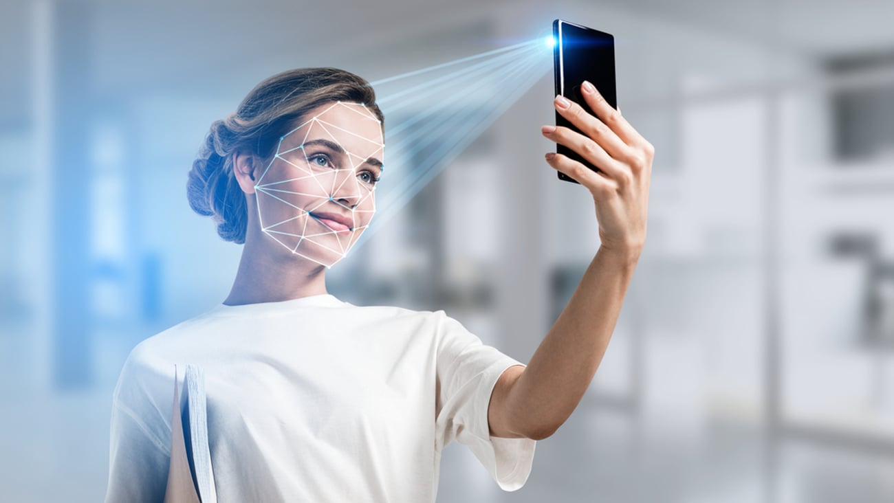 a woman holding up a camera for biometric face scans