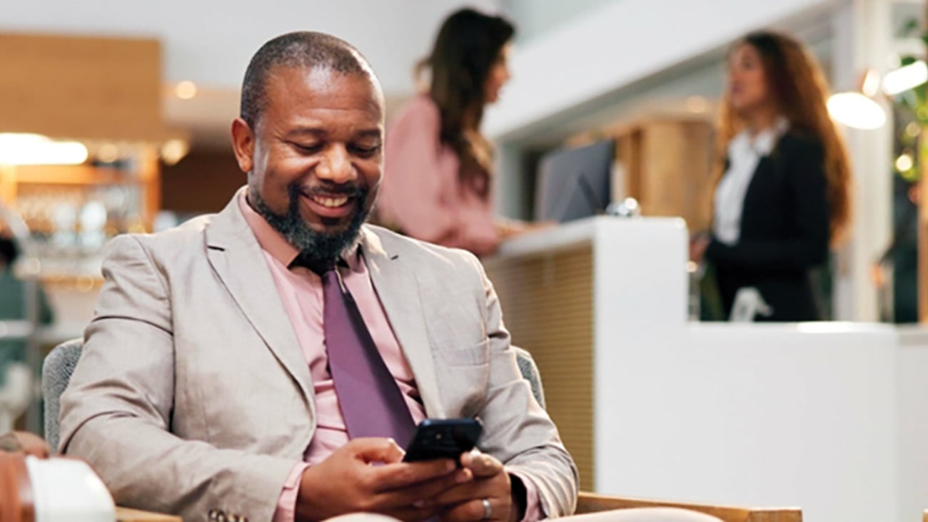 man looking at smartphone in hotel lobby