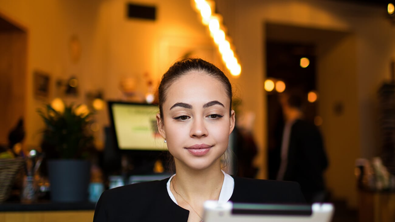 Serious woman skilled publication specialist reading article on web site via touch pad computer while resting in restaurant. Female hostess using digital tablet. Online shopping store ; Shutterstock ID 1316152481
