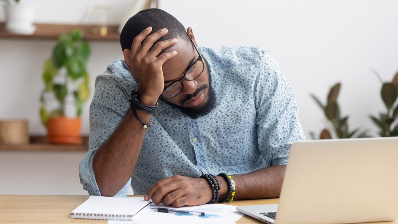 Tired depressed bored african businessman frustrated by business failure bankruptcy looking at laptop feel exhausted having headache, upset stressed black office worker worried about problem at work; Shutterstock ID 1368244247