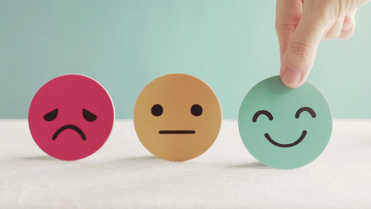 Hand choosing happy smile face paper cut, good feedback rating and positive customer review, experience, satisfaction survey ,mental health assessment, child wellness,world mental health day concept; Shutterstock ID 1735801265