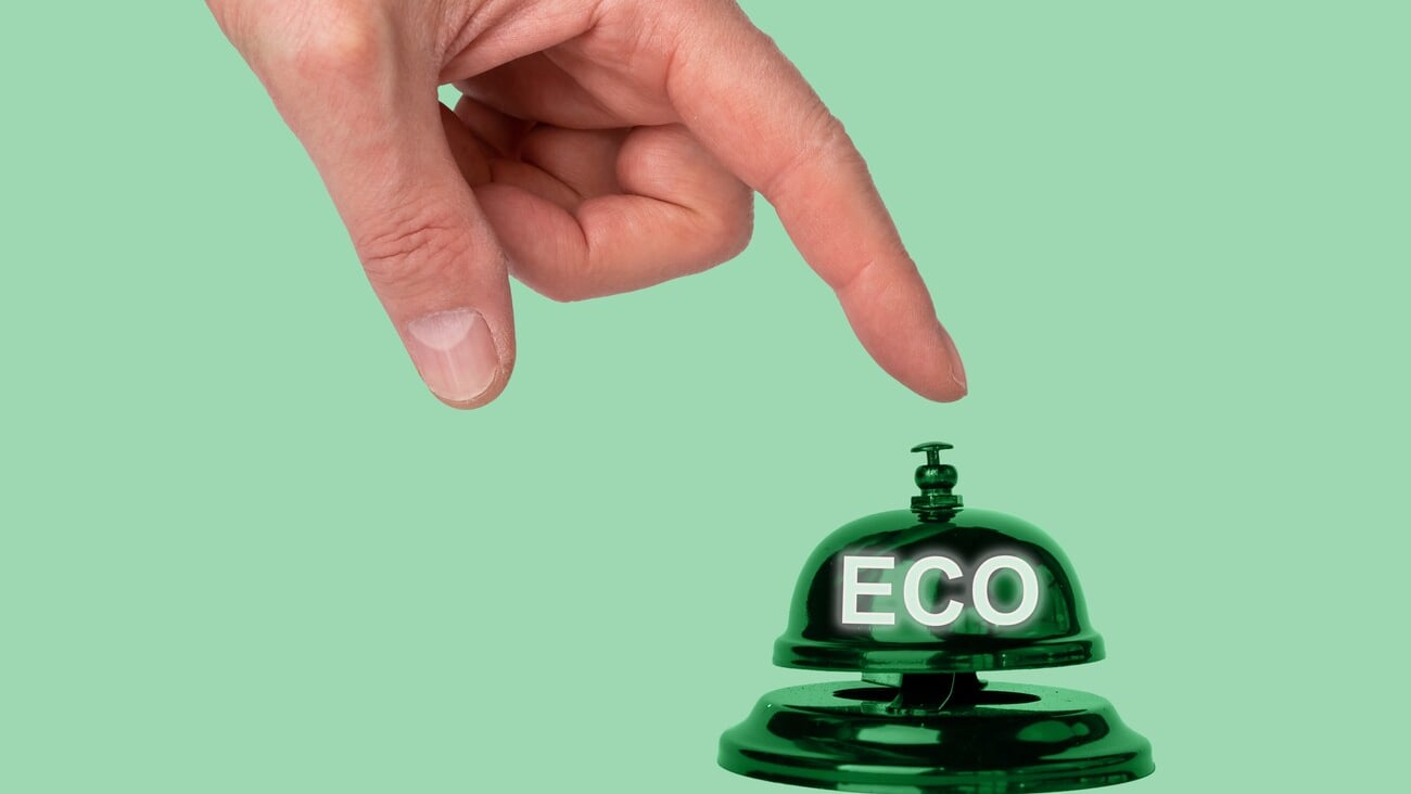 Hand pressing reception bell with word eco. Choice in favor of ecology and environmentally friendly products in hotel, store, cafe, restaurant. High quality photo; Shutterstock ID 2170548201