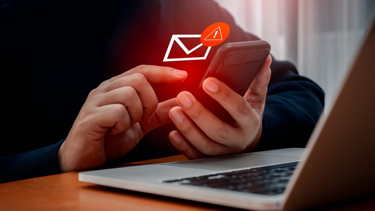 SMS spam, fake text message phishing from scammer concept. System hacked red warning alert, email hack, scam malware spreading virus on message alert virtual on mobile phone screen in person hand.; Shutterstock ID 2495795811