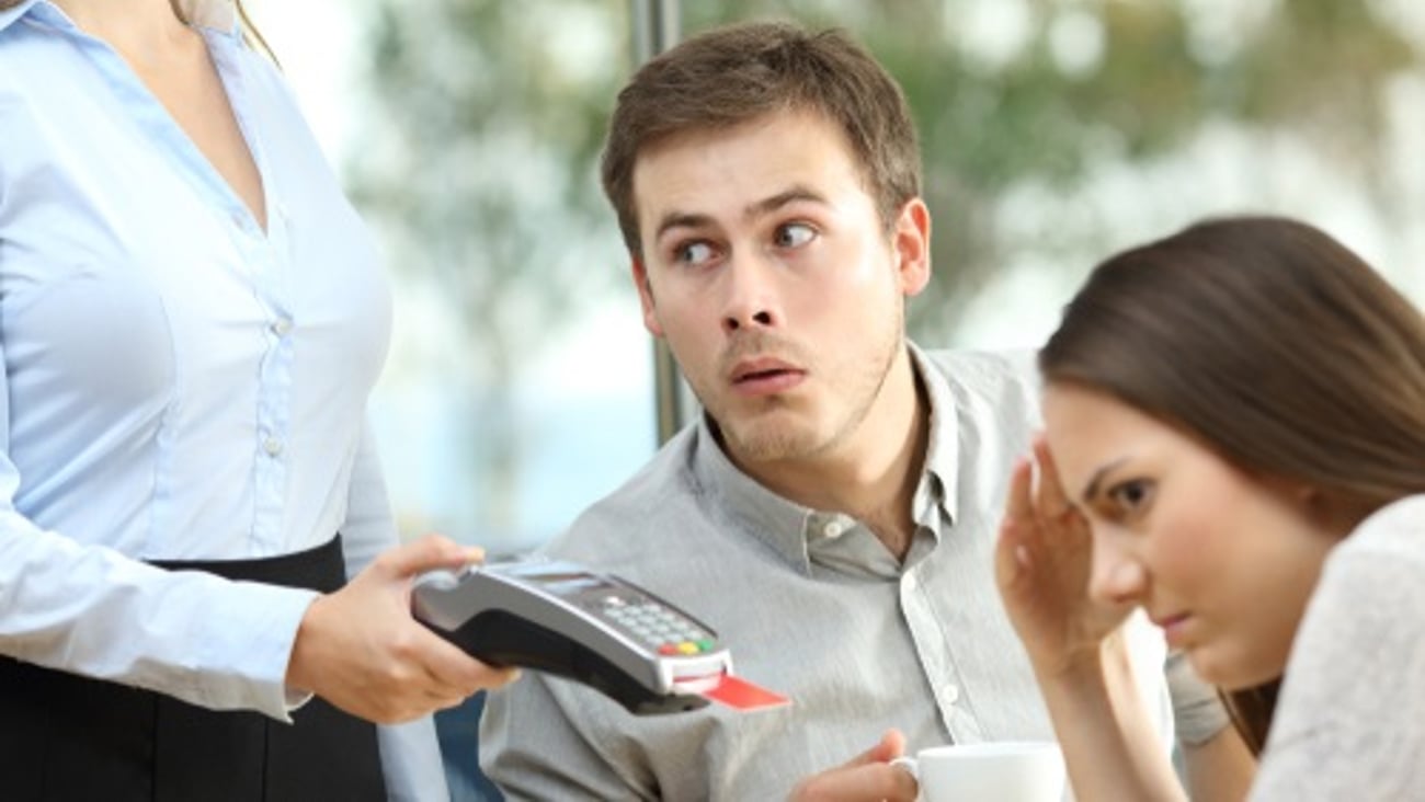 skeptical man facing a payment terminal