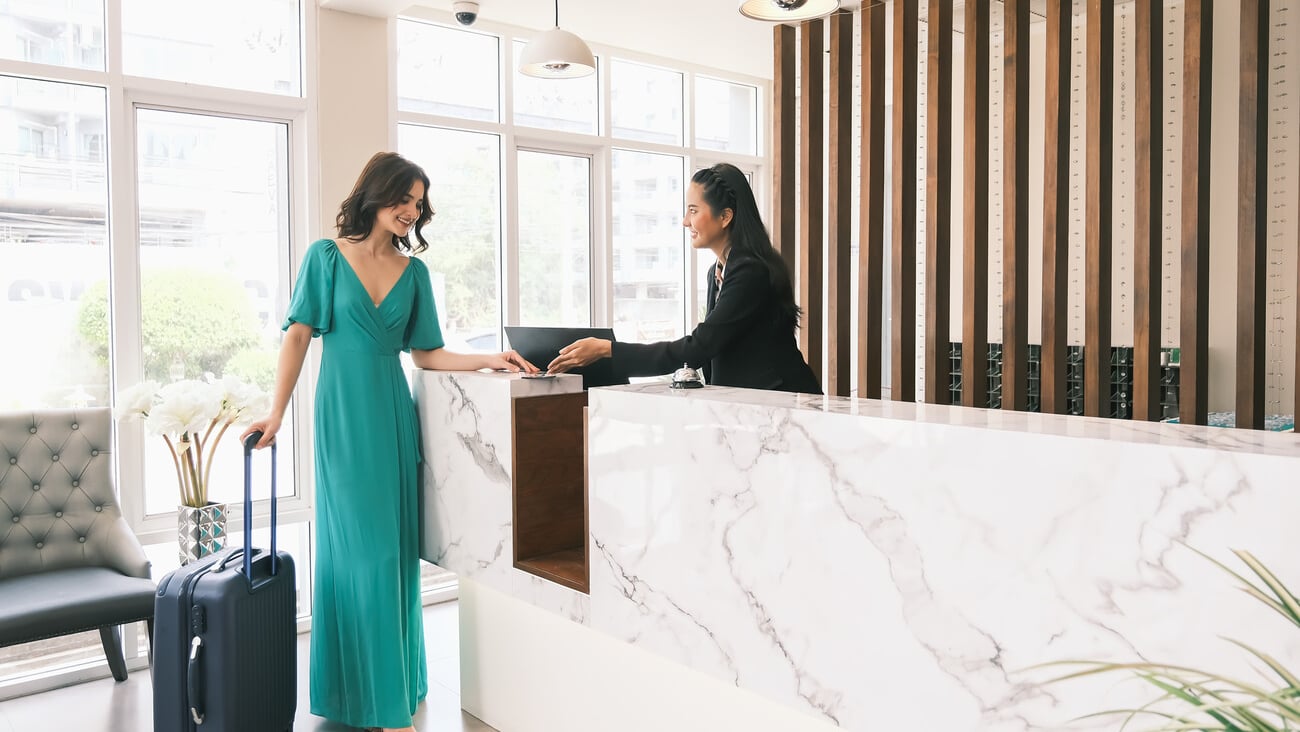 Asian girl receptionist and Caucasian woman traveler checking or checkout in hotel; Shutterstock ID 1964198212