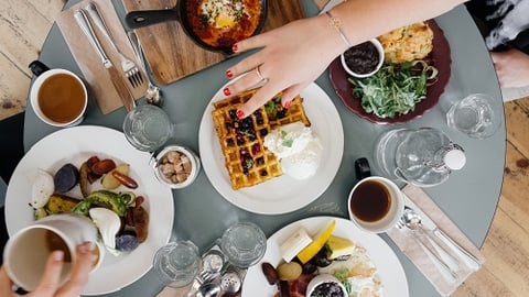 a person sitting at a table with a plate of food