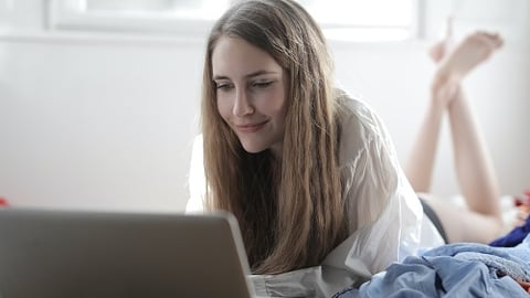 a woman sitting in front of a laptop