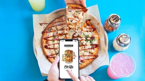 a woman holding a piece of pizza