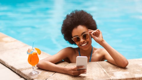 a person sitting at a table looking at a cell phone