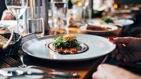 a group of people sitting at a table with a plate of food