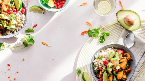 a bowl of salad on a plate on a table