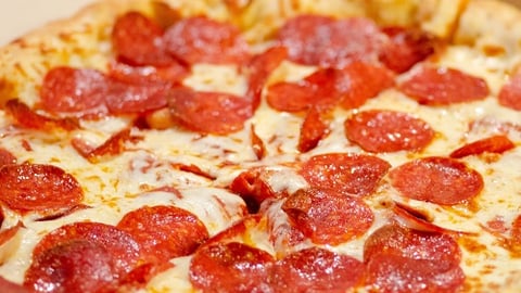 a close up of a slice of pepperoni pizza on a plate