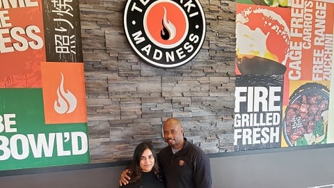 a man and a woman standing in front of a sign