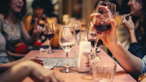 a group of people sitting at a table with wine glasses