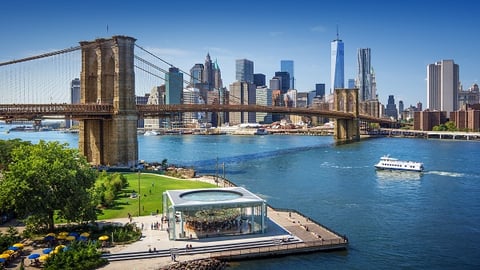 a bridge over a body of water with a city in the background