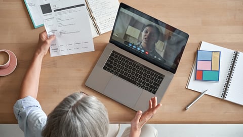 a group of people sitting at a table with a laptop