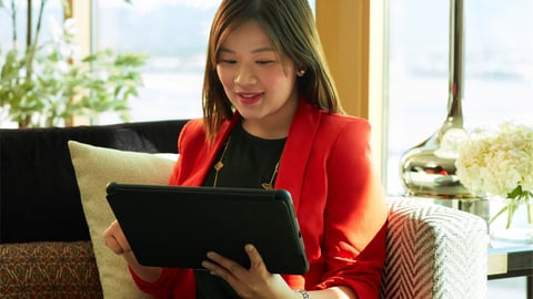 a woman sitting at a table using a laptop computer