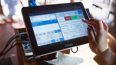 a person sitting at a table in front of a monitor