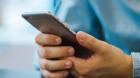 a man hand holding a cellphone sending a sms