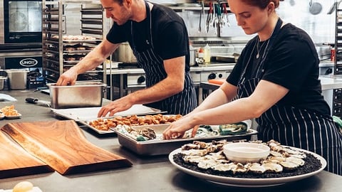 a group of people preparing food in a kitchen