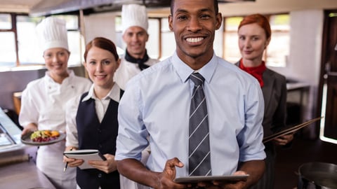 a group of people standing in a kitchen