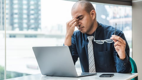 a man sitting at a table using a laptop