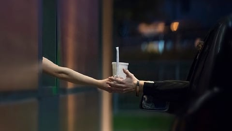 a close up of a person getting food in a drive thru