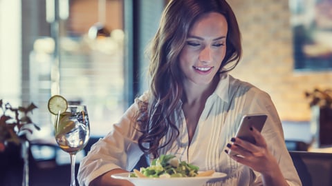 a woman sitting at a table with a plate of food