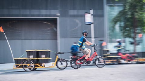 a man riding a bicycle to deliver restaurant food 