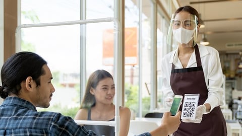 a group of people at a restaurant paying with credit card