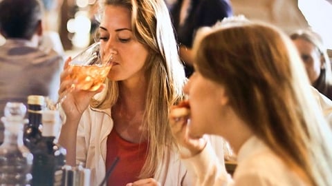 a woman drinking a glass of wine