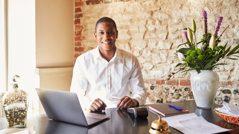 a person sitting at a table using a laptop