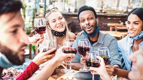 a group of people are drinking from a wine glass