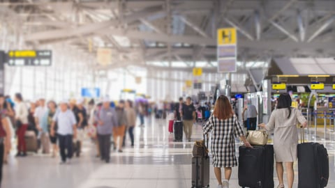 a group of people waiting for their luggage at an airport