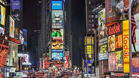 a close up of a busy city street with Times Square in the background