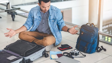 man looking in suitcase for lost item