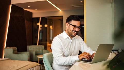 Man working on laptop in hotel room