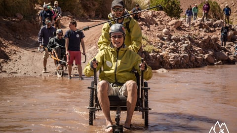 Wheelchair-bound persons on a hike, near a lake