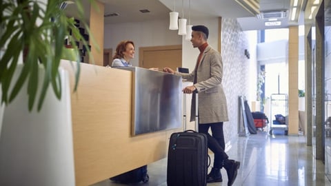 a person holding luggage at hotel desk