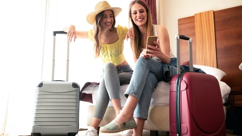 two happy women with their luggage getting ready to travel