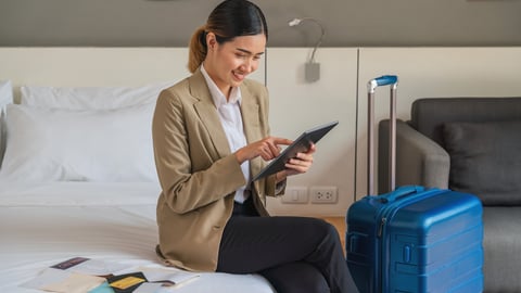 a woman sitting on a bed next to her suitcase