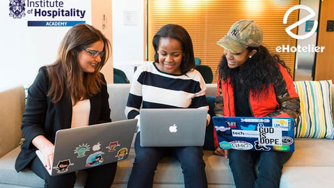 a group of people looking at multiple laptops