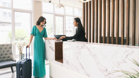 Woman checking in at hotel front desk