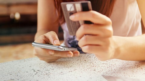 Woman holding a mobile phone and credit card