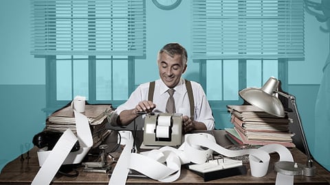 a man sitting at a desk in front of a window