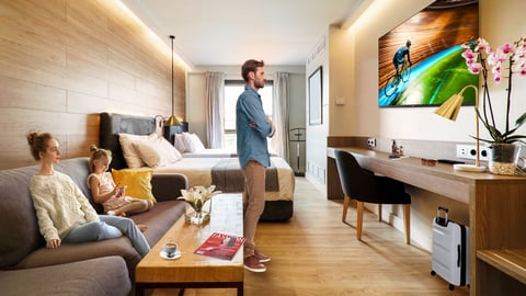 Family watching the TV in a hotel room