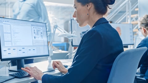 woman looking at spreadsheets on a laptop