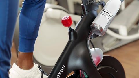 Hotel guest riding Peloton bike in Hilton Hotel Fitness Center